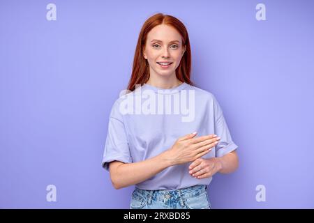 fille rousse souriante émotive agréable expliquant quelque chose avec les mains, gros plan portrait isolé fond bleu photo studio Banque D'Images