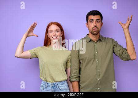 Jeune couple sourd muet avec des gestes mains paumes disant stupide closeup portrait isolé fond bleu Banque D'Images