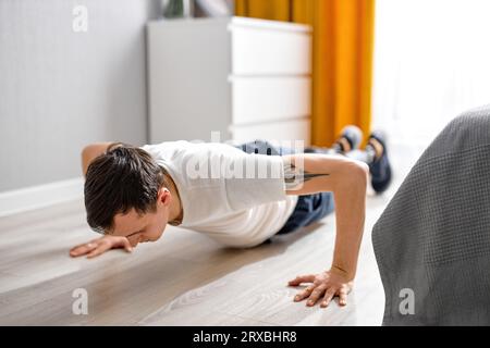 Homme handicapé amputé. Jeune homme caucasien avec entraînement de prothèse de jambe à la maison, faisant de l'entraînement. positivité corporelle et concept d'estime de soi. Désactivé Banque D'Images