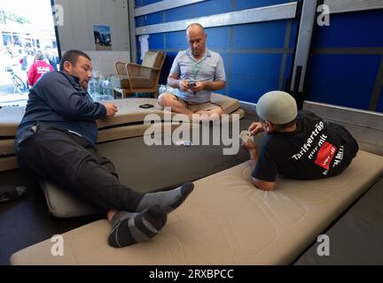 24 septembre 2023, Hesse, Gräfenhausen : les camionneurs d'Europe de l'est s'assoient dans la soute d'un camion à l'arrêt de repos de Gräfenhausen et jouent aux cartes. Ici, de nombreux camionneurs sont en grève depuis plus de deux mois pour le paiement de leur salaire par un transitaire polonais. Certains des chauffeurs sont en grève de la faim depuis des jours. Photo : Boris Roessler/dpa Banque D'Images