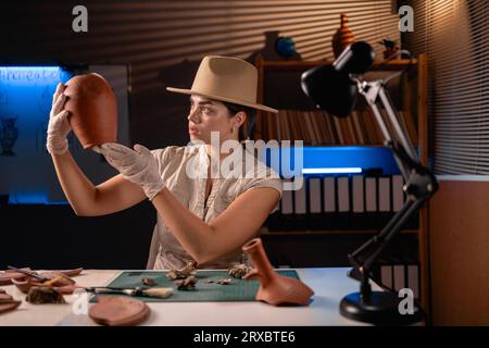 Archéologue travaillant avec le navire antique tard dans la nuit dans le bureau. Banque D'Images