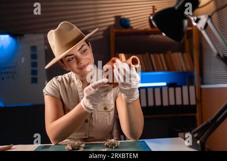 Archéologue travaillant avec le navire antique tard dans la nuit dans le bureau Banque D'Images