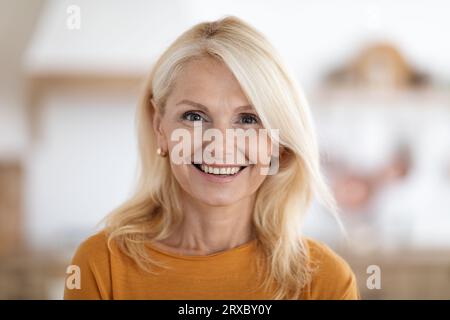 Heureuse belle femme âgée élégante posant à la maison Banque D'Images