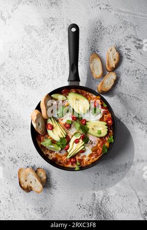 Shakshuka dans une poêle en fer. Plat traditionnel du Moyen-Orient de style mexicain. Banque D'Images