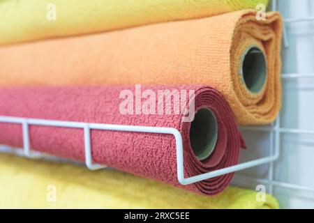 Tapis roulés en rouleaux sur une étagère dans un marché Banque D'Images