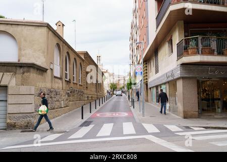 Figueres, Espagne, 14 mai 2023 : une rue à sens unique avec des voitures et des piétons. Sur le panneau asphalté limite de vitesse 20 km par heure Banque D'Images