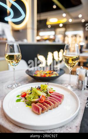 Salade de tataki au thon avec laitue, tomates cerises et avocat sur une table en marbre dans un restaurant. Photo de haute qualité Banque D'Images