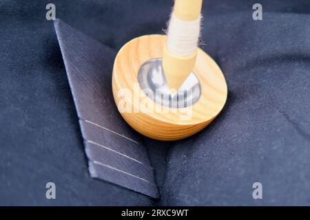 La femme tourne soigneusement la laine dans le fil en utilisant une broche de goutte, mettant en valeur son habileté dans le métier de filage. Banque D'Images