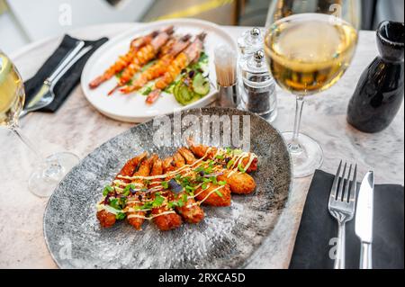 Crevettes royales battues dans un imperméable panko avec une sauce sur une assiette grise Banque D'Images