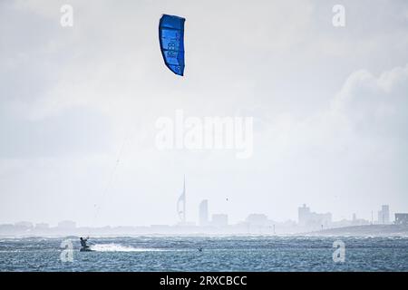 Kitesurf sur la plage de West Wittering avec Portsmouth et la Tour Spinnaker au loin Banque D'Images