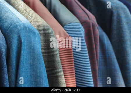 Racks avec différents costumes pour hommes dans une boutique de vêtements pour hommes. Banque D'Images