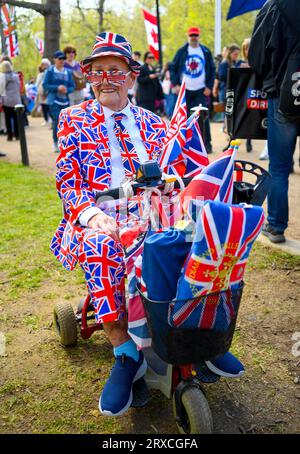 Un OAP habillé entièrement en vêtements Union Jack dans un scooter de mobilité au Mall London England célébrant le couronnement du roi Charles. Banque D'Images