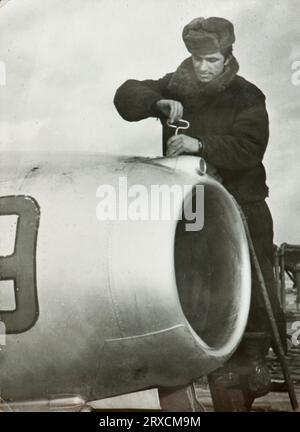 Un technicien russe répare son chasseur à réaction soviétique MIG-15 bis quelque part en Estonie pendant l'occupation russe à la fin des années cinquante Banque D'Images