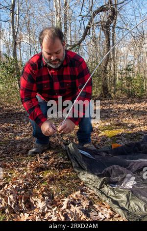 Un couple monte une tente sur un terrain de camping. Les deux sont handicapés mais adorent le plein air. Banque D'Images