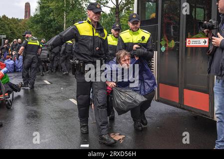 Un activiste qui a refusé de quitter le blocus est emmené par la police dans un bus qui les conduira au stade de football ado pendant le rassemblement. La manifestation non violente d’occupation d’aujourd’hui sur l’Utrechtsebaan, était le quinzième jour du blocus de protestation de l’A12 à la Haye. La police a arrêté samedi 552 militants qui bloquaient partiellement l'A12 à la Haye, 200 ont été arrêtés hier. Extinction les manifestations de la rébellion ont bloqué la route d'entrée principale de l'A12 pour le quinzième jour consécutif, exigeant que le gouvernement cesse de soutenir les industries des combustibles fossiles. Polic Banque D'Images