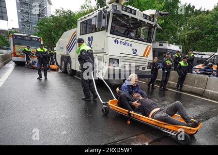 Un activiste qui a refusé de quitter le blocus est emmené par la police dans un bus qui les conduira au stade de football ado pendant le rassemblement. La manifestation non violente d'aujourd'hui sur l'Utrechtsebaan, était le quinzième jour du blocus de protestation de l'A12 à la Haye. La police a arrêté samedi 552 militants qui bloquaient partiellement l'A12 à la Haye, 200 ont été arrêtés hier. Extinction les manifestations de la rébellion ont bloqué la route d'entrée principale de l'A12 pour le quinzième jour consécutif, exigeant que le gouvernement cesse de soutenir les industries des combustibles fossiles. Polic Banque D'Images