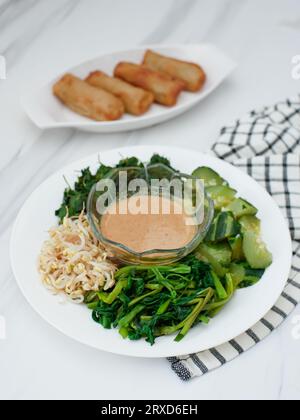 pecel sayur ou mélange de légumes cuits à la vapeur avec sauce aux arachides. Nourriture traditionnelle de Java central ou de Java oriental, Indonésie Banque D'Images