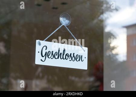 Panneau avec inscription allemande geschlossen sur une vitrine sale dans le centre-ville de Magdebourg en Allemagne. Traduction : fermé Banque D'Images