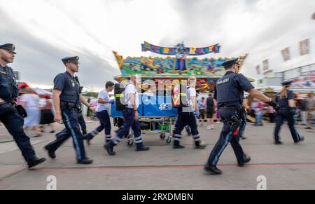 Munich, Allemagne. 21 septembre 2023. Les policiers de la patrouille de Wiesn sécurisent une opération de l'ambulance sur la zone d'Oktoberfest, qui emmène un homme ivre. Crédit : Peter Kneffel/dpa/Alamy Live News Banque D'Images