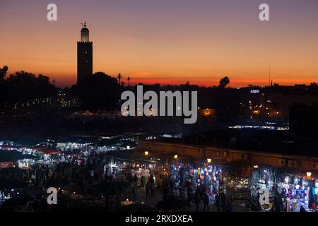 Marrakech, Maroc - janvier 28 2019 : Jemaa el-Fnaa au coucher du soleil avec la mosquée Koutoubia derrière. Banque D'Images