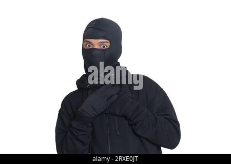 Mystérieux voleur portant un sweat à capuche noir et un masque a été attrapé en se faufilant. Criminel choqué et effrayé. Image isolée sur fond gris Banque D'Images