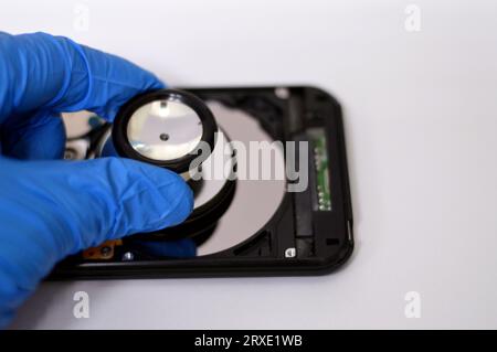 Un stéthoscope médical sur les plateaux HDD et le moteur de l'axe, disque dur démonté composants endommagés, maintenance de l'ordinateur, exécution des diagnostics, r Banque D'Images