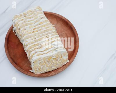 tempeh brut ou tempeh. tranches de tempeh sur plaque en bois. Le tempeh est fabriqué à partir de soja fermenté Banque D'Images