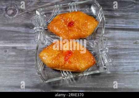 Mini pâtisserie danoise farcie et garnie de sirop sucré de miel et de cerise, foyer sélectif de pâte de boulangerie sucrée cuite au four avec flo Banque D'Images