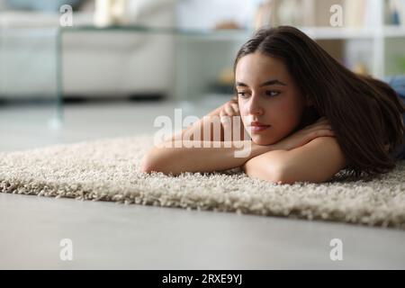 Femme triste couchée sur le sol à la maison dans la nuit Banque D'Images