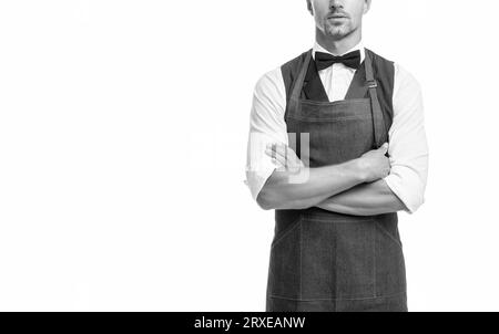 Homme plein de confiance vue de récolte dans l'arc et le tablier barman en gardant les bras croisés isolés sur blanc, espace de copie Banque D'Images