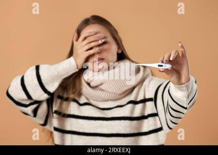 femme avec une forte fièvre mesurant la température corporelle au thermomètre Banque D'Images