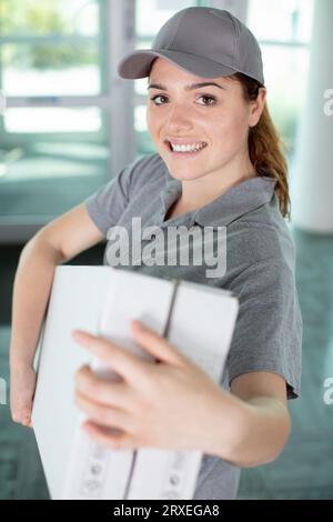 jeune coursier heureux avec des boîtes dans ses mains Banque D'Images