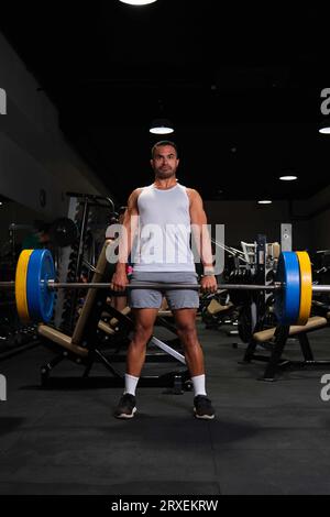 Un homme hispanique fort soulevé de terre dans une salle de gym. Banque D'Images