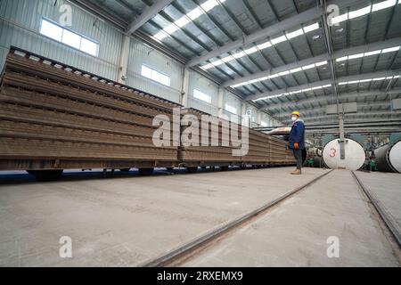 Luannan, Chine - 13 février 2023 : les travailleurs contrôlent les équipements de traction pour transporter de nouveaux matériaux de construction - panneaux de silicate de calcium - à partir d'autoclaves Banque D'Images