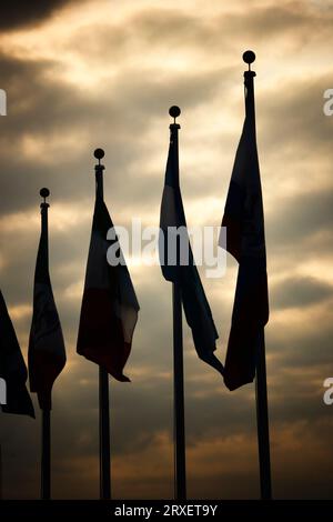 Une rangée de drapeaux silhouettés contre un ciel orageux. Banque D'Images