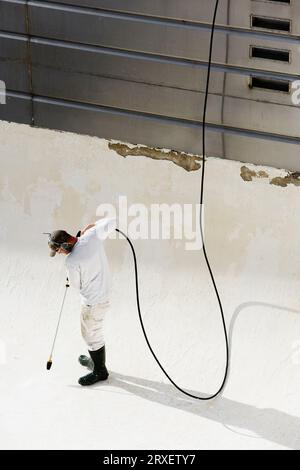 Un homme de puissance lavant une piscine vide. Banque D'Images