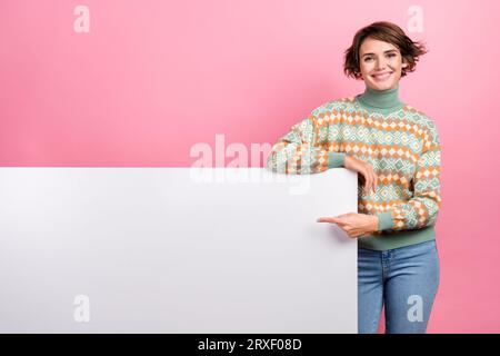 Photo de promoteur jeune femme brun point de cheveux doigt énorme panneau d'affichage démontrer nouvelle bannière d'invitation d'événement isolé sur fond de couleur rose Banque D'Images