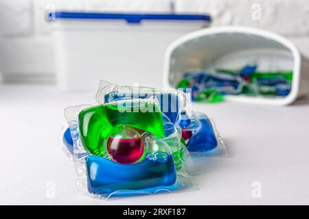 Capsules de blanchisserie et récipients en plastique isolés sur fond blanc. Photo de haute qualité Banque D'Images