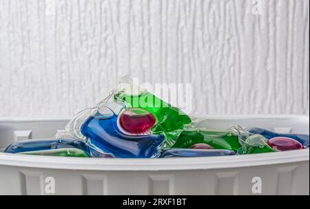 Capsules de blanchisserie et récipients en plastique isolés sur fond blanc. Photo de haute qualité Banque D'Images