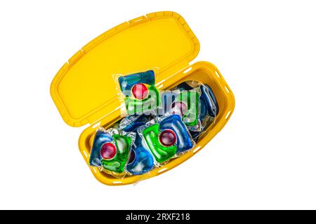 capsules de lavage colorées dans un récipient en plastique isolé sur fond blanc. Photo de haute qualité Banque D'Images