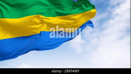 Drapeau national du Gabon agitant dans le vent par temps clair. Trois bandes horizontales égales de vert, jaune et bleu. rendu d'illustration 3d. Battement Banque D'Images