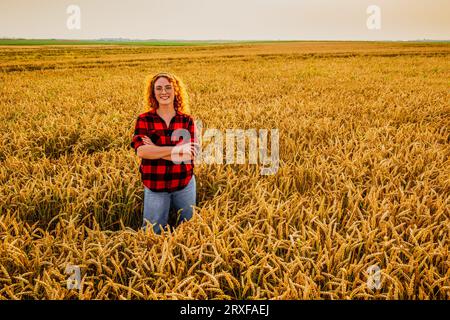 Portrait d'une agricultrice qui cultive du blé. Elle est satisfaite de la bonne progression des plantes. Occupation agricole. Banque D'Images