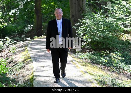 Wiesbaden, Allemagne. 25 septembre 2023. Georg Bätzing, président de la Conférence épiscopale allemande et évêque de Limbourg, se tient à l'ombre des arbres à la Maison Wilhelm Kempf au début de la réunion plénière d'automne de la Conférence épiscopale allemande. La Conférence épiscopale allemande est l'association des évêques des 27 (arches)diocèses d'Allemagne. Il compte actuellement 65 membres. Cette année, la réunion d'automne se tiendra à Wiesbaden-Naurod jusqu'au 28 septembre. Crédit : Arne Dedert/dpa/Alamy Live News Banque D'Images