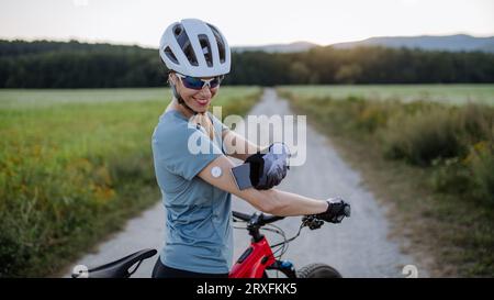 Cycliste diabétique connectant un moniteur de glycémie continu à son smartphone pour surveiller son taux de sucre dans le sang en temps réel. Banque D'Images