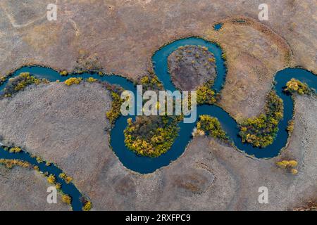 GREATER KHINGAN, CHINE - 24 SEPTEMBRE 2023 - le fleuve sinueux de la zone humide internationale du fleuve Nanweng est vu dans les montagnes du Grand Khingan Banque D'Images