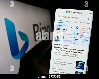 Personne tenant le téléphone portable avec le site Web du moteur de recherche Web Microsoft Bing sur l'écran en face du logo de l'entreprise. Concentrez-vous sur le centre de l'écran du téléphone. Banque D'Images