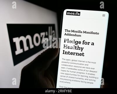 Personne détenant smartphone avec le site Web de l'organisation open source Mozilla Foundation sur l'écran avec logo. Concentrez-vous sur le centre de l'écran du téléphone. Banque D'Images
