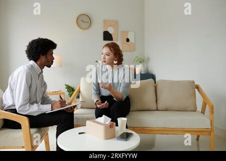Jeune femme parlant de son problème relationnel en psychologue de bureau Banque D'Images
