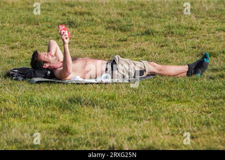 Londres Royaume-Uni. 25 septembre 2023. Un homme bronzer dans le soleil d'automne sur Wimbledon Common, au sud-ouest de Londres par une chaude journée à Londres que les températures atteignent 22C . Crédit amer ghazzal/Alamy Live News Banque D'Images