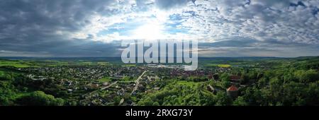 Vue aérienne de Koenigsberg en Bavière. La ville est entourée de collines et de forêts. Le ciel est nuageux et sombre, indiquant une tempête qui approche. Banque D'Images